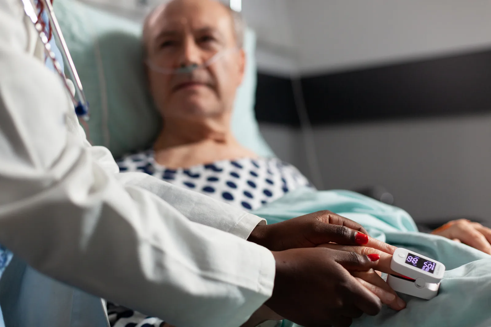 Paciente em leito hospitalar recebendo cuidado de profissional de saúde